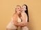 Portrait Of Two Happy Body Positive Women In Underwear Over Beige Background