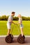 Portrait of two happy lovers standing on segways and going to kiss