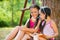 Portrait of two happy sisters reading in the park