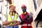 Portrait of two happy smiling industrial African American worker engineer man and woman wearing safety vest and helmet, standing