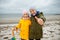 Portrait of two happy teenagers staing on coast of Baltic sea at windy rainy weather