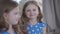 Portrait of two identical twin sisters with brunette hair and grey eyes smiling. Focused at face of happy child at the