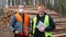 Portrait two logging workers. Face mask, tablet in hand. Focus attention camera.