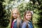 Portrait of two long haired preteen girls while smiling.