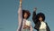 Portrait of two mixed race woman with huge afro hair makes a protest black raised fist gesture