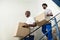 Portrait Of Two Movers Holding Cardboard Boxes