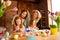 Portrait of two nice attractive cheerful ladies helping assisting two girls doing decorative things dying eggs in house