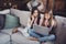 Portrait of two nice-looking lovely attractive charming clever smart funny curious girls sitting on divan using laptop
