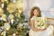 Portrait of two one young girls sisters close to white green Christmas tree. The girls in beautiful evening dresses clothes in New
