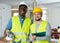 Portrait of two positive builders holding a hammer drill and working documents