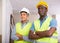 Portrait of two positive builders standing in construction site