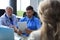 Portrait of two practitioners consulting patient in hospital