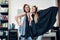 Portrait of two pretty blondes wearing hair rollers and cape standing in funny silly pose looking in camera at