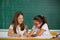 Portrait of two schoolgirls in a classroom.