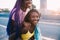 Portrait of two sisters black women outdoor having fun hugging riding piggyback