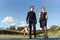 Portrait of two smiling business people, man and woman, walking by plane hangar in airport field