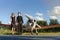 Portrait of two smiling business people, man and woman, walking by plane hangar in airport field