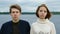 Portrait of two teenagers, a guy and a girl, against the background of a river and forest.