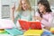 Portrait of two thoughtful schoolgirls doing homework together at home