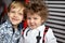 Portrait of two tough brothers play in the kids room hug and make friends in beautiful elegant shirts