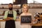 Portrait of two waiters holding a board written open