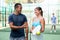 Portrait of two woman and man in sportswear on outdoor court with paddle racket and ball in hands after match, talking