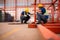 Portrait of two workers using digital tablet sit in front of the red steel