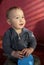 Portrait of a two years old boy sitting on the floor and smiling