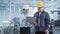 Portrait of Two Young Asian Heavy Industry Engineers in Hard Hats Standing with Laptop Computer and