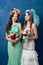 Portrait of two young attractive brides on blue background