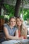 Portrait of two young beautiful women sitting near a table. Happy persons.