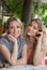 Portrait of two young beautiful women sitting near a table. Happy persons.