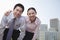 Portrait of two young business people leaning forward, outside in the business district, Beijing