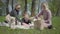 Portrait two young cute mothers with them kids sit on the blanket in green amazing park on nature on spring day. Mom and