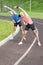 Portrait of Two Young Feale Sportswomen Having Stretching Exercises Outdoors