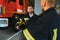 Portrait of two young firemen in uniform standing inside the fire station