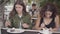 Portrait of two young girlfriends trying cakes sitting in cafe outdoors. Young girls together enjoying their meals