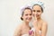 Portrait of two young girls in funny headbands smearing their noses with cream on a light background. Studio. Beauty and care