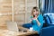 Portrait of unbelievable young girl freelancer with blonde bob haircut hair in blue blouse are sitting in cafe, working on laptop