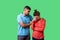 Portrait of unhappy worried young couple in casual wear standing together. isolated on green background