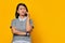 Portrait of unhappy young Asian woman while receiving incoming call on smartphone on yellow background