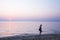 Portrait of unidentified bare-chested men with tote bag walking barefoot on a beach at sunset. Blurred motion. Long exposure.