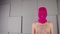 Portrait of unrecognizable man in pink balaclava. Hooligan in mask looking at camera.