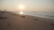 Portrait of unrecognizable woman staying on the sandy beach. Waves of Mediterranean Sea rolling to the sand at sunset or