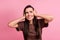 Portrait of unsatisfied stressed lady arms close ears grin teeth look empty space isolated on pink color background