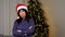 Portrait upset aged woman in Santa Claus hat crosses hands looks camera at home