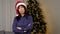 Portrait upset aged woman in Santa Claus hat crosses hands looks camera at home