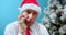 Portrait an upset middle-aged father in a Christmas Santa hat. Man with a sad face in christmas sits alone, looks at