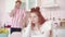 Portrait of upset thoughtful woman sitting in kitchen as blurred redhead man talking on the phone at the background
