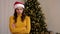 Portrait upset young woman in Santa Claus hat crosses hands looks camera at home